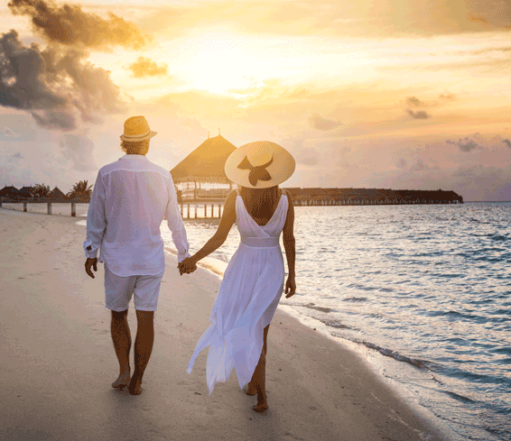 Couple walk a tropical beach holding hands